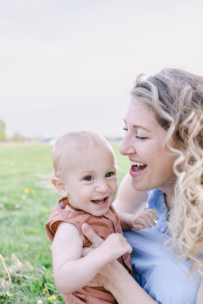 mother holds young son, laughing and smiling 
