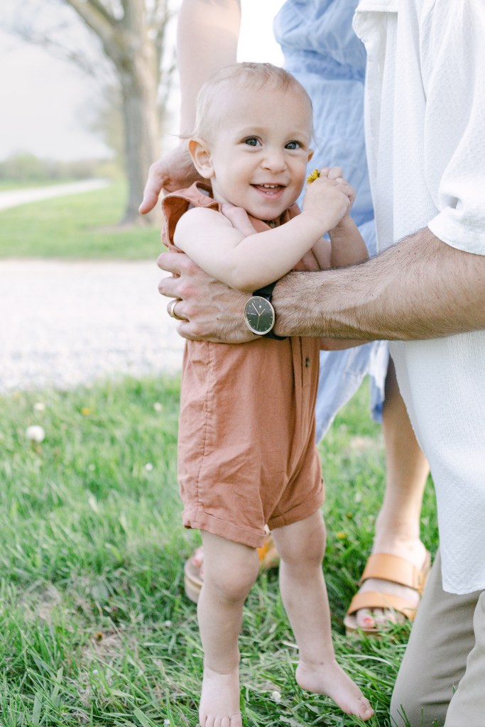 young boy child is held by his parents 